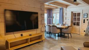 a living room with a large television and a table at Chaty Wald in Karpacz