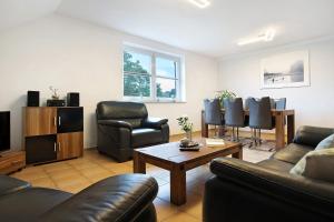 a living room with a couch and chairs and a table at Ferienwohnung Bella in Fuhlendorf