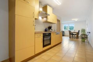 a large kitchen with yellow cabinets and a table at Ferienwohnung Bella in Fuhlendorf