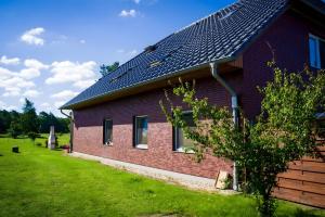 a red brick house with a solar roof at Ferienwohnung Bella in Fuhlendorf