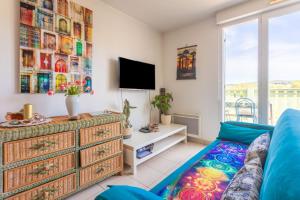 a living room with a couch and a tv at T3 au calme avec terrasse in Cogolin