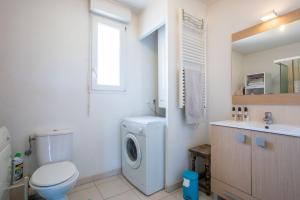 a bathroom with a washing machine and a sink at T3 au calme avec terrasse in Cogolin +16 photos