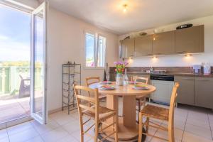 a kitchen and dining room with a table and chairs at T3 au calme avec terrasse in Cogolin