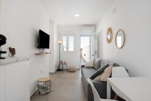 a white living room with a couch and a table at Casa Lavanda Vejer in La Muela