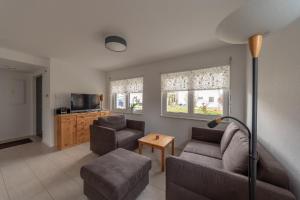 a living room with a couch and chairs and a tv at Ferienwohnung Gluiber in Beuren