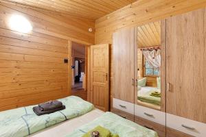 a log cabin bedroom with a bed and a mirror at Ferienhaus Waldblick in Berlin