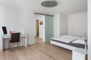 a bedroom with a bed and a desk with a computer at Ferienwohnung Feine Natur in Bahlingen