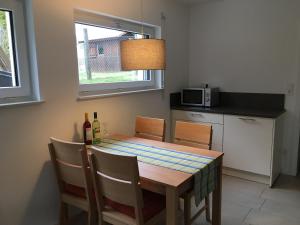 a kitchen with a table with chairs and a microwave at Ferienwohnung Gluiber in Beuren +18 photos
