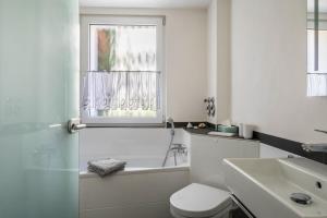 a bathroom with a tub and a toilet and a sink at Ferienwohnung Feine Natur in Bahlingen +25 photos