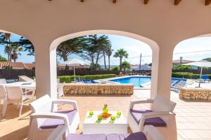 a patio with chairs and a table and a pool at Villa Arena Blanca in Sant Lluis