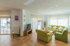 a living room with a couch and a tv at Villa Arena Blanca in Sant Lluis