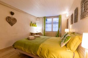 a bedroom with a large yellow bed with a window at Cocon Familial - Gîte De Charme in Die