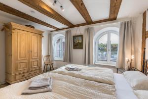 a bedroom with a large bed and two windows at Ferienwohnungen Metzgerpost in Altensteig