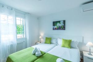 a white bedroom with a bed and a window at Villa Arena Blanca in Sant Lluis +36 photos