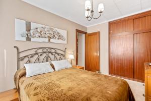 a bedroom with a bed and a wooden cabinet at Sanpolicarpo in Torrevieja