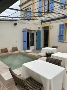 a swimming pool with a table and chairs in front of a building at L'Escale Au Soleil in Saint-Aygulf