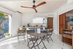 a kitchen with tables and chairs and a ceiling fan at L'Escale Au Soleil in Saint-Aygulf