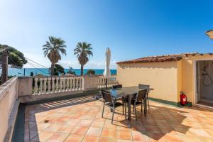 a patio with a table and chairs and the ocean at L'Escale Au Soleil in Saint-Aygulf