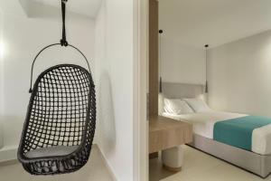 a bedroom with a bed and a hanging chair at Mella Roa - Ivory in Nydri +16 photos