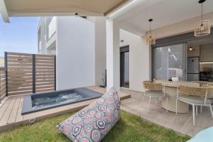 a patio with a table and chairs and a fireplace at Mella Roa - Ivory in Nydri