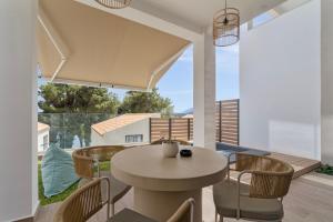 a dining room with a table and chairs on a balcony at Mella Roa - Ivory in Nydri