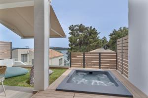 a hot tub on the deck of a house at Mella Roa - Ivory in Nydri