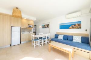a living room and kitchen with a couch and a table at Apartamento Aquamarina 6 in Cala Ferrera