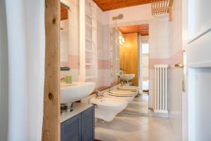 ein Badezimmer mit drei Waschbecken und zwei Toiletten in der Unterkunft Wunderhorn in Civezzano + 37 Fotos