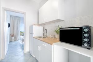 a white kitchen with a sink and a refrigerator at Spyridoula Studio 2 in Paleokastritsa