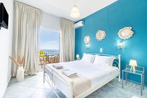 a blue bedroom with a bed and a balcony at Spyridoula Studio 2 in Paleokastritsa