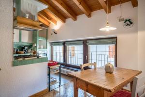 eine Küche und ein Esszimmer mit einem Holztisch in der Unterkunft Wunderhorn in Civezzano
