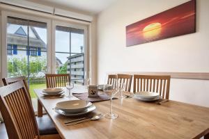 a wooden table with plates and wine glasses on it at Ferienhaus Seestern in Dranske +17 photos