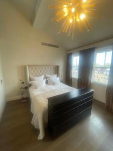 a bedroom with a large bed and a large chandelier at 51 Hotel Apartment in London