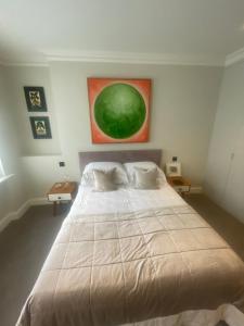 a bedroom with a large bed and a painting on the wall at 51 Hotel Apartment in London +17 photos