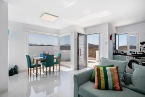 a living room with a couch and a table with chairs at Ocean 1 in La Santa