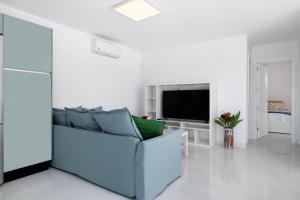 a living room with a blue couch and a television at Ocean 1 in La Santa