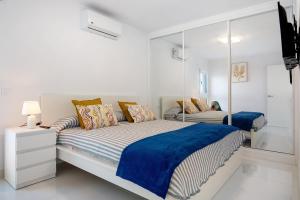 a white bedroom with a bed and a mirror at Ocean 1 in La Santa