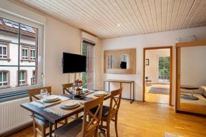 a dining room with a table and chairs and a television at Luise in Bad Bergzabern