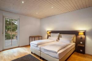a bedroom with a bed with white sheets and a window at Luise in Bad Bergzabern