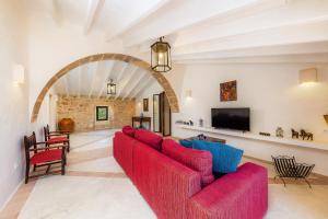a living room with a red couch and a tv at Finca So na Sopa in Artá