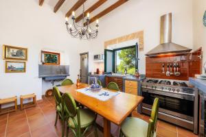 a kitchen with a wooden table and a stove at Finca So na Sopa in Artá