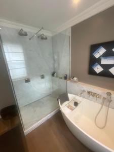 a bathroom with a shower and a bath tub at 51 Hotel Apartment in London