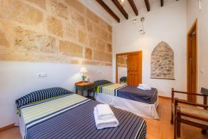 two beds in a room with a stone wall at Finca So na Sopa in Artá +34 photos