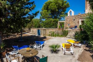 a patio with chairs and a wooden table and chairs at Finca So na Sopa in Artá