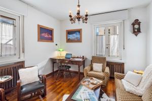 a living room with a table and a desk at Dimora Il Feudo - Predazzo in Predazzo +23 photos