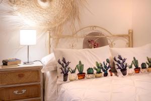 a bed with four pillows with cactuses on it at Suite Carlomaria in Ceglie in Ceglie Messapica