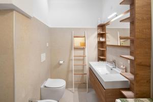 a bathroom with a white toilet and a sink at Dimora Il Feudo - Predazzo in Predazzo