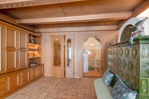 a large room with a kitchen with wooden walls at Dimora Il Feudo - Predazzo in Predazzo