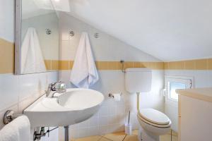 a bathroom with a sink and a toilet at Mansarda di Ponente in Caorle +17 photos