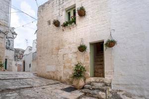 an alley with potted plants on the side of a building at Suite Carlomaria in Ceglie in Ceglie Messapica +11 photos